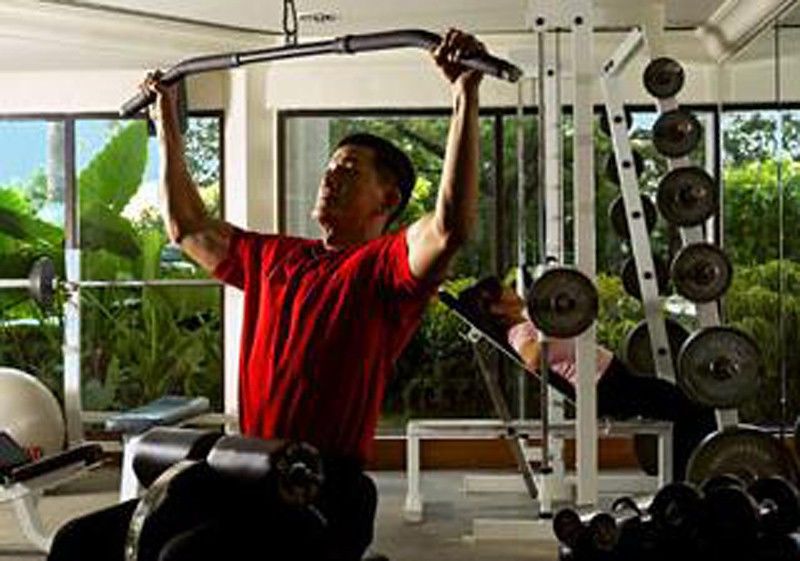 Dorsett Grand Subang Hotel Subang Jaya Facilidades foto A man using a lat pulldown machine